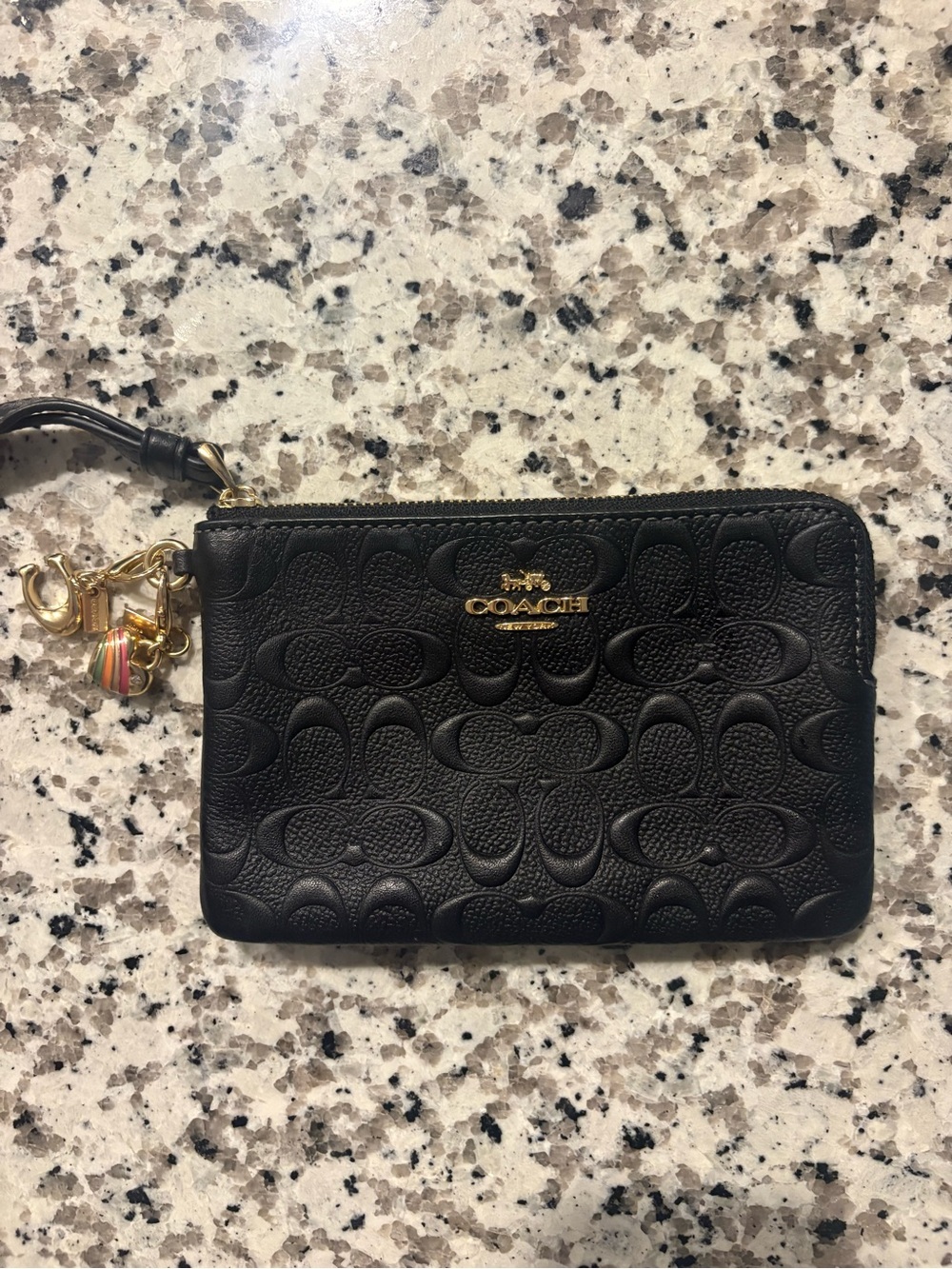 COACH Black Embossed Signature Leather Wristlet with Gold Hardware and charms.